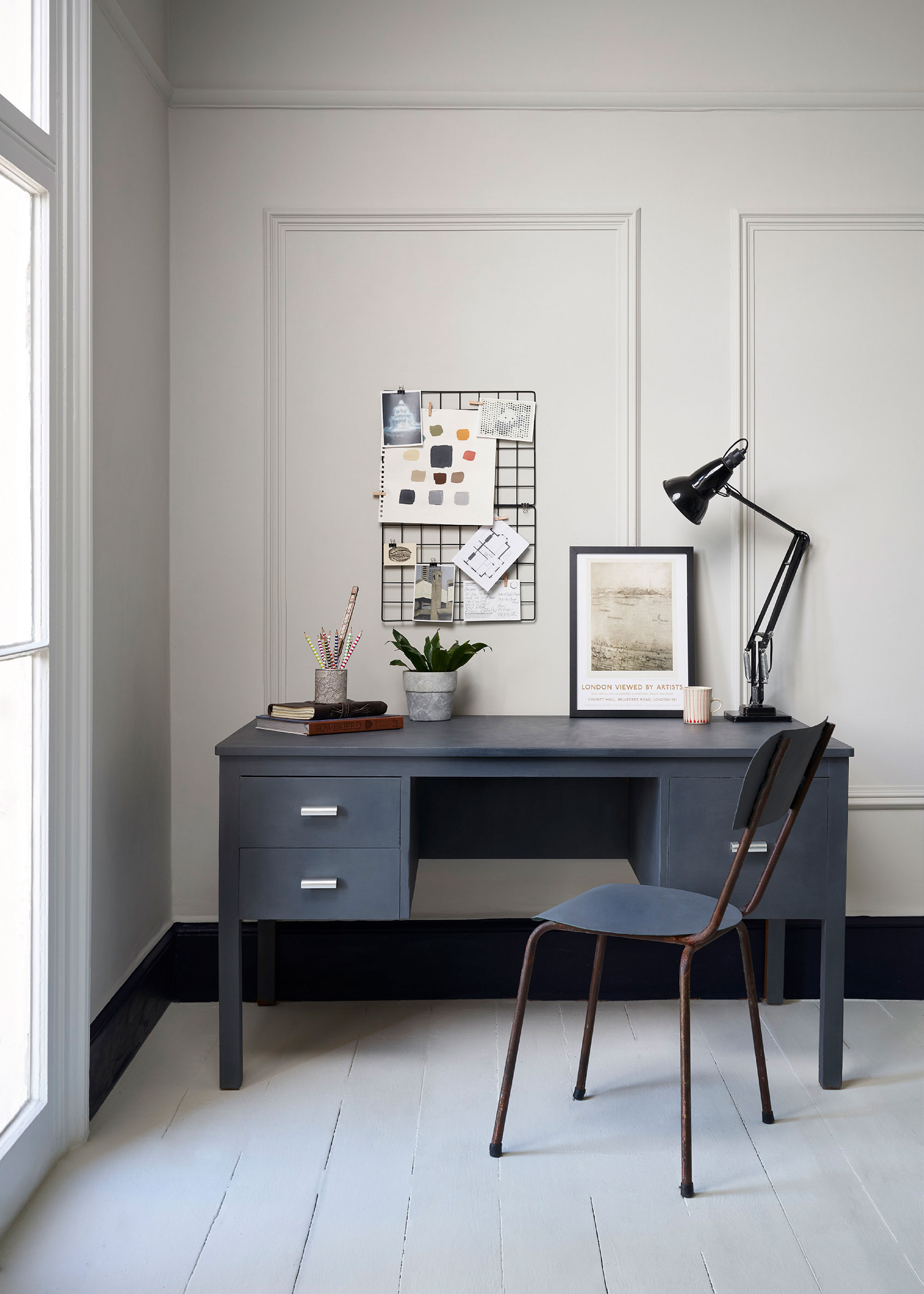 blue desk in home office with white wooden floorboards