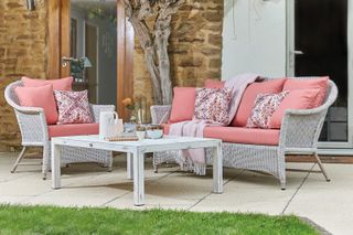 outdoor sofa ideas: sofa and chairs with coral cushions
