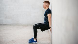 Man performing wall squat outdoors