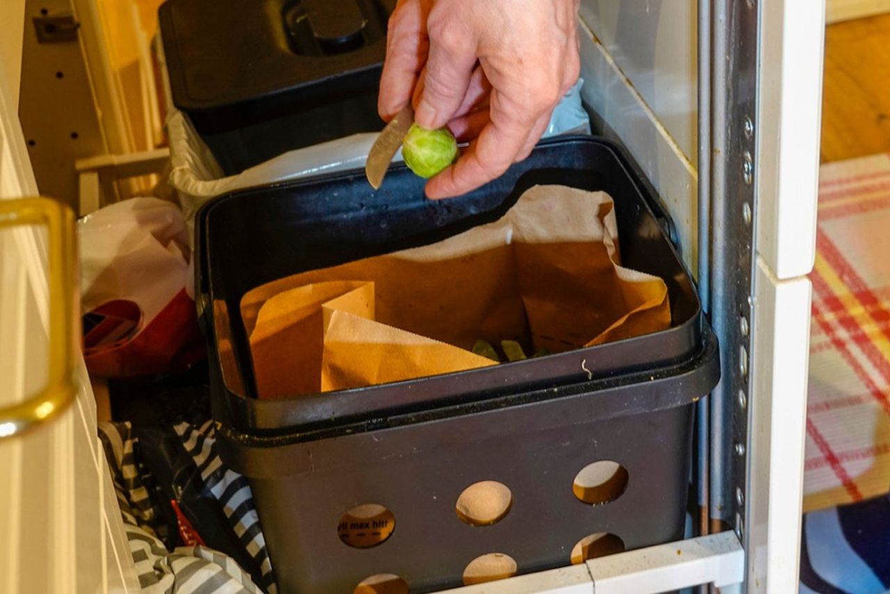 Hand Dropping Food Into A Compost Bin