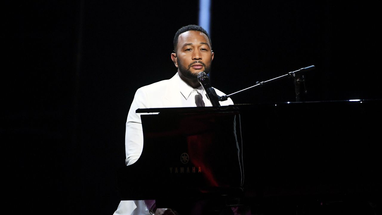 John Legend performs sat at a piano.