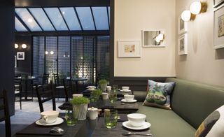 Hotel dining room with green bench seating, black table and chairs