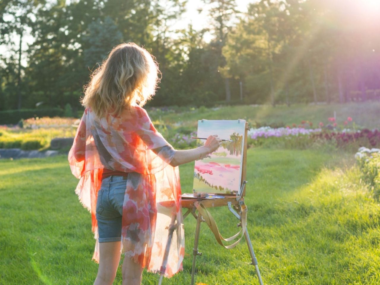 Woman Painting A Flower Landscape In The Garden