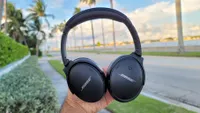 Наушники Bose QuietComfort 45 на фоне прибрежной улицы с пальмами