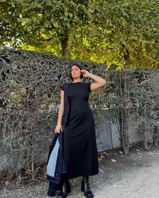 @isabellecoheen wearing a black dress and boots