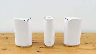 Netgear Orbi 373 with one router and two satellites on a wooden table