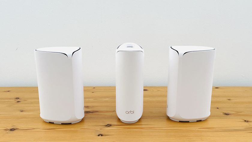 Netgear Orbi 373 with one router and two satellites on a wooden table