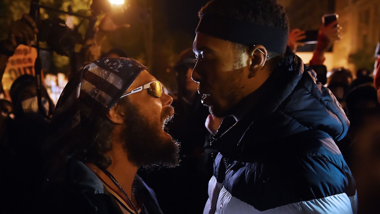 A Donald Trump supporter (left) clashes with a Black Lives Matter demonstrator near the White House