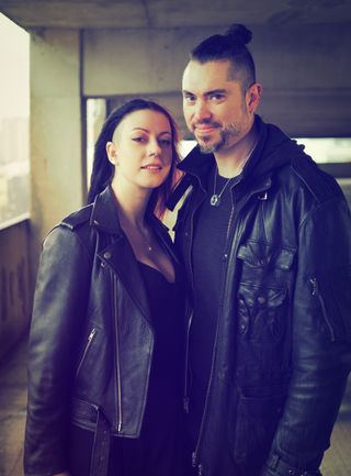 Portrait of a couple wearing leather jackets, in an industrial setting, taken on the OM System OM-3 with the OM System 25mm f/1.8 II lens