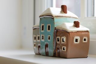 Ornament of pottery houses sitting on a windowsill