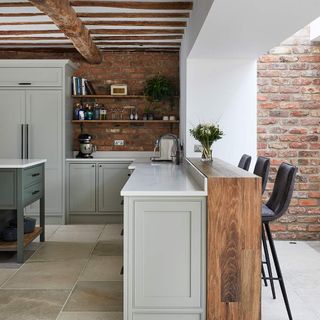 kitchen area with bricked wall and wooden beam and marble countertop