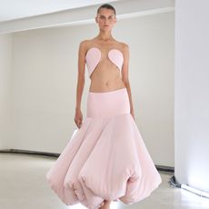 a model wears a light pink cutout dress