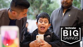 Young boy making funny face while using an iPhone X