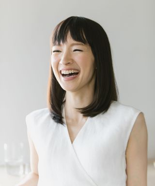 marie kondo wearing a white shirt on a cream background