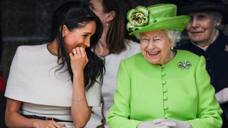 Queen Elizabeth II sitts and laughs with Meghan, Duchess of Sussex during a ceremony to open the new Mersey Gateway Bridge
