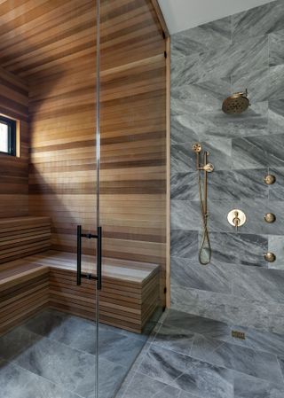 A walk in shower with wooden cladding and surrounding gray marbel tiles