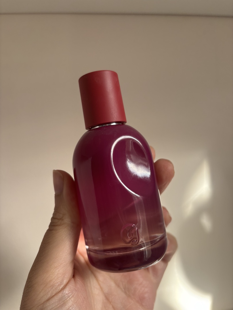 Mica Ricketts holding bottle of Glossier You R&amp;ecirc;ve