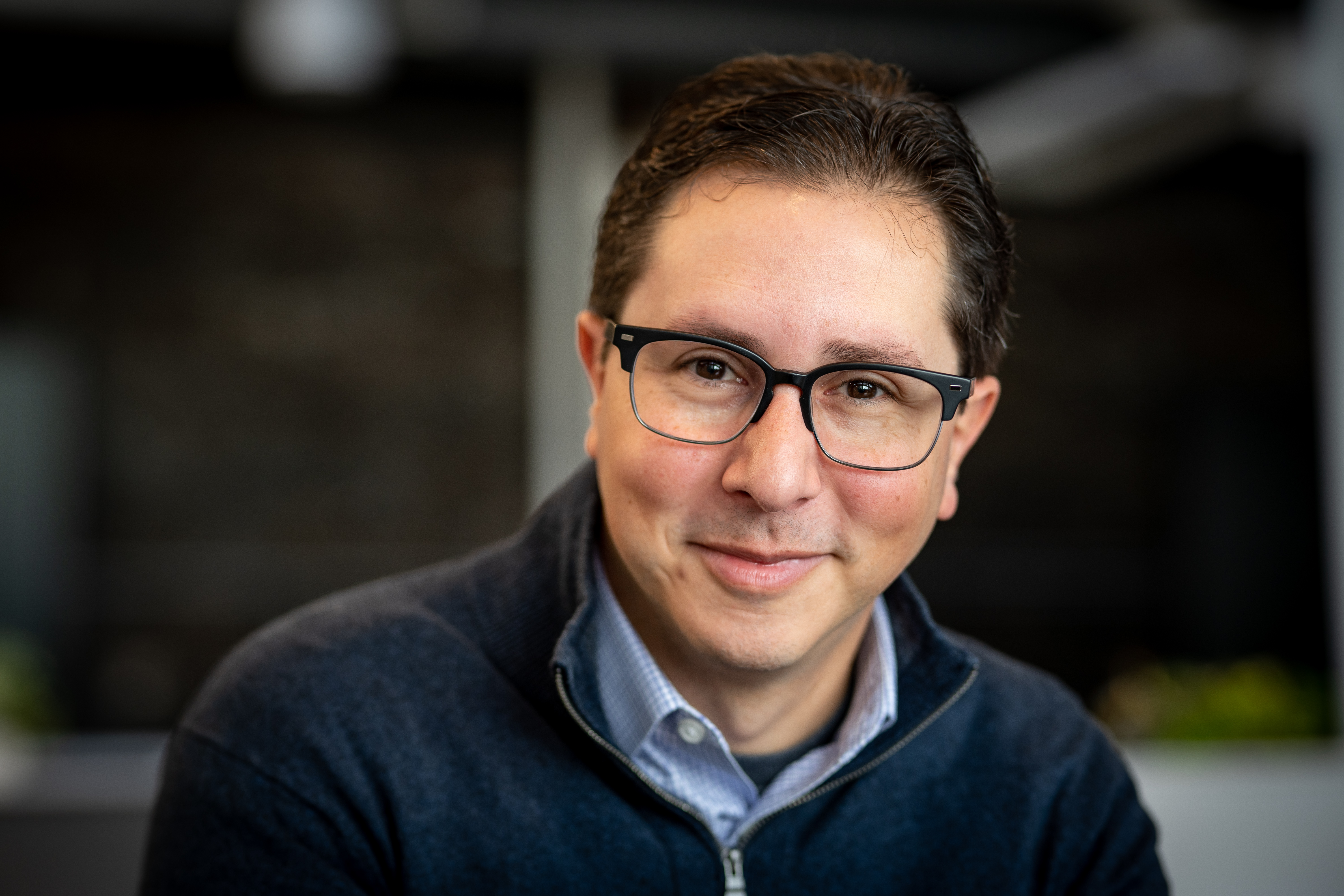 man with glasses and a zipper top