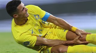 Cristiano Ronaldo holds his leg in pain after suffering an injury playing for Al-Nassr against Al-Hilal in August 2023.