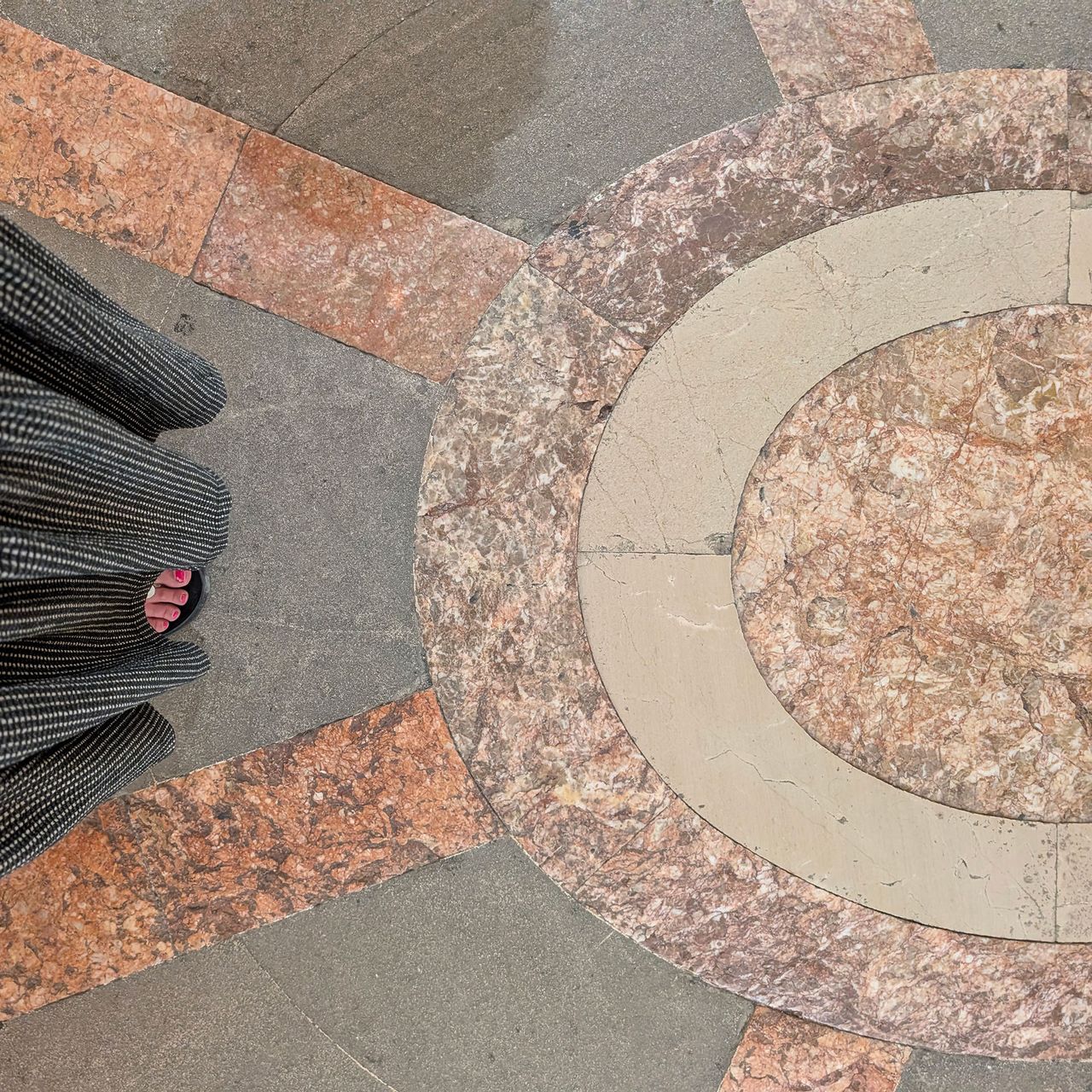 Person standing over stone and marble patterned ground