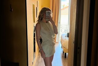 Eliza Huber wearing a Tory Burch draped minidress in a mirror selfie.