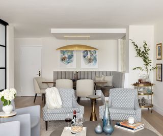 living room with blue chairs and white walls with dining area behind