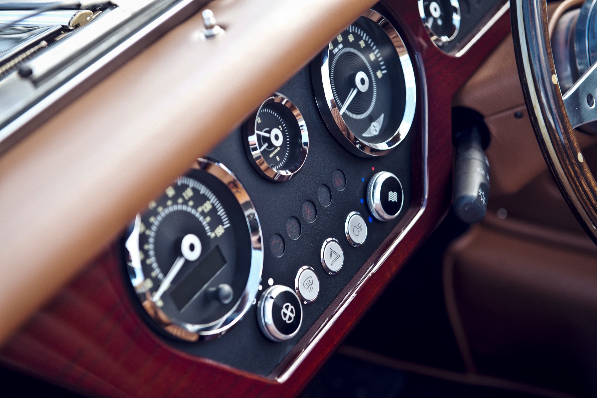 A view of the interior of a morgan plus four, showing analogue dials and brown leather
