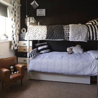 monochrome kids room with bunk bed, brown carpet and mini armchair