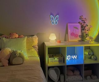 pastel lights in a bedroom with a bed full of stuffed animals and a cubby dresser