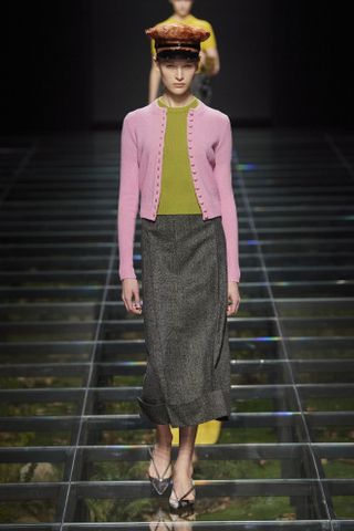 Woman in pink cardigan on the Prada runway.