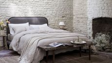 Naturalmat Organic Hemp Bed Linen Collection on a bed against a gray wall.