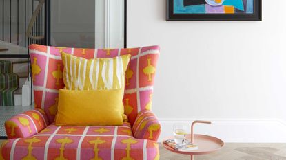 a brightly colored chair in front of a white wall