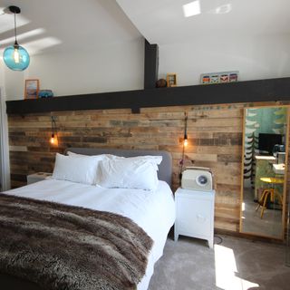 bedroom with wooden wall and bed with bedside table