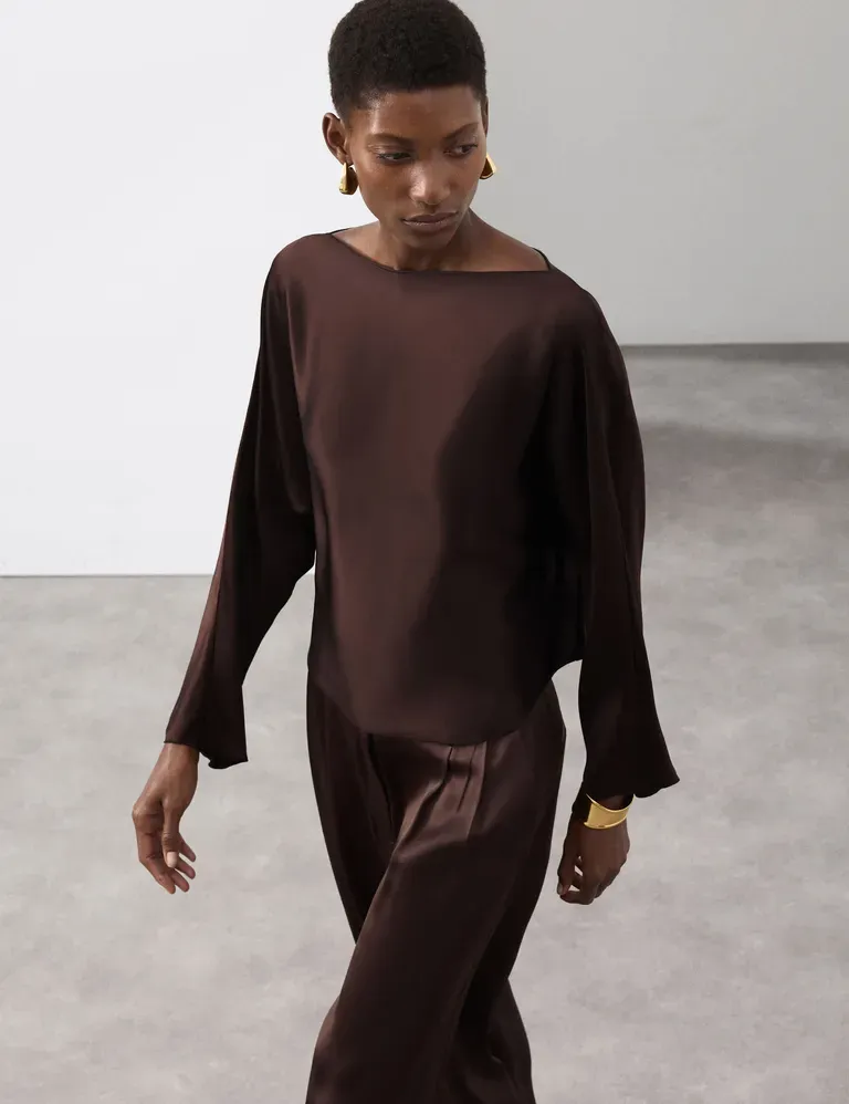 Woman wears satin top and satin trousers