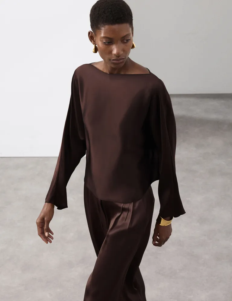 Woman wears satin top and satin trousers