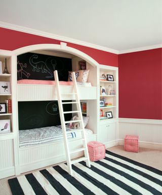 built in bunk beds with arched opening, blackboard painted walls inside bunks and red walls around them