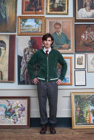 Model wears Oliver Spencer A/W 2022, standing in front of paintings