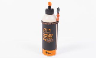 The image shows a bottle of tyre sealant on a white background