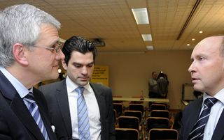 Belgian cycling federation president Tom van Damme (center) speaks with Flemish Minister-President Kris Peeters (left) an unidentified man during a meeting between the minister and the Belgian team that won the Cyclocross World Championship race in 2012.