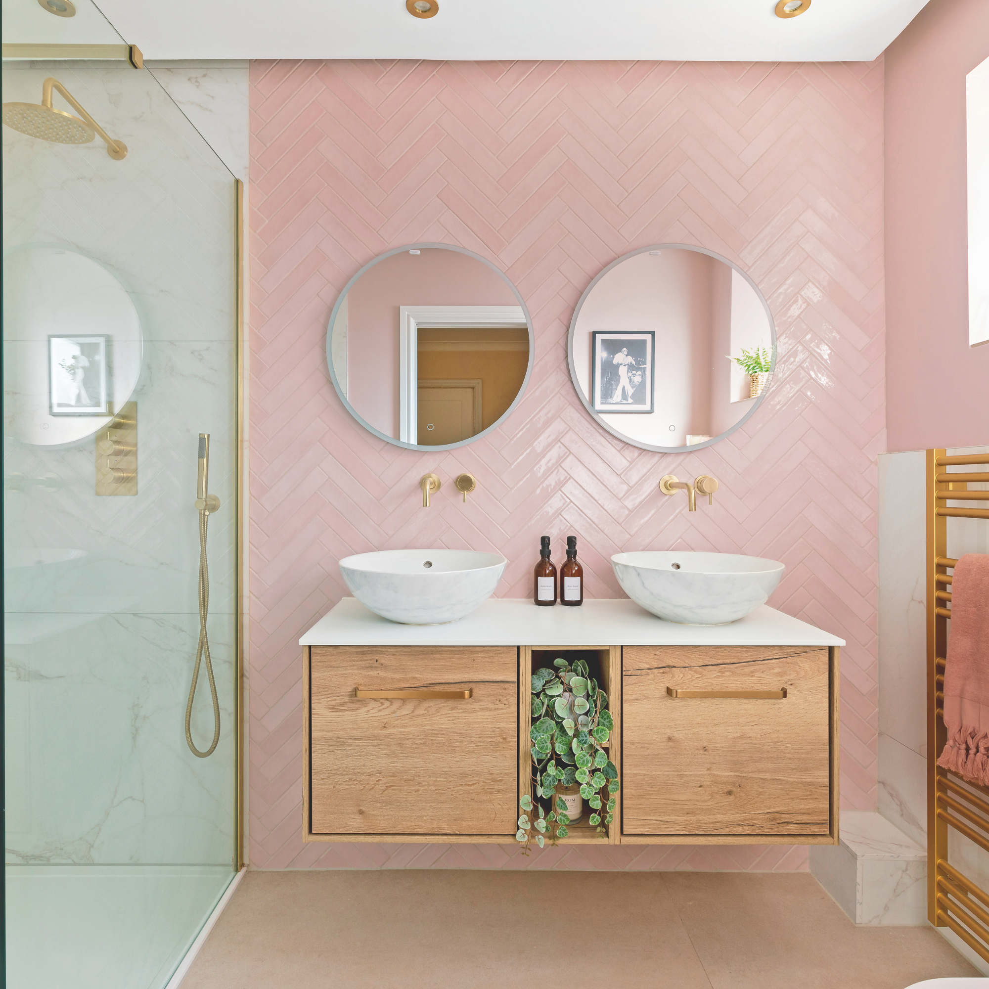 Bathroom with chevron pink tiled wall and double floating vanity unit.