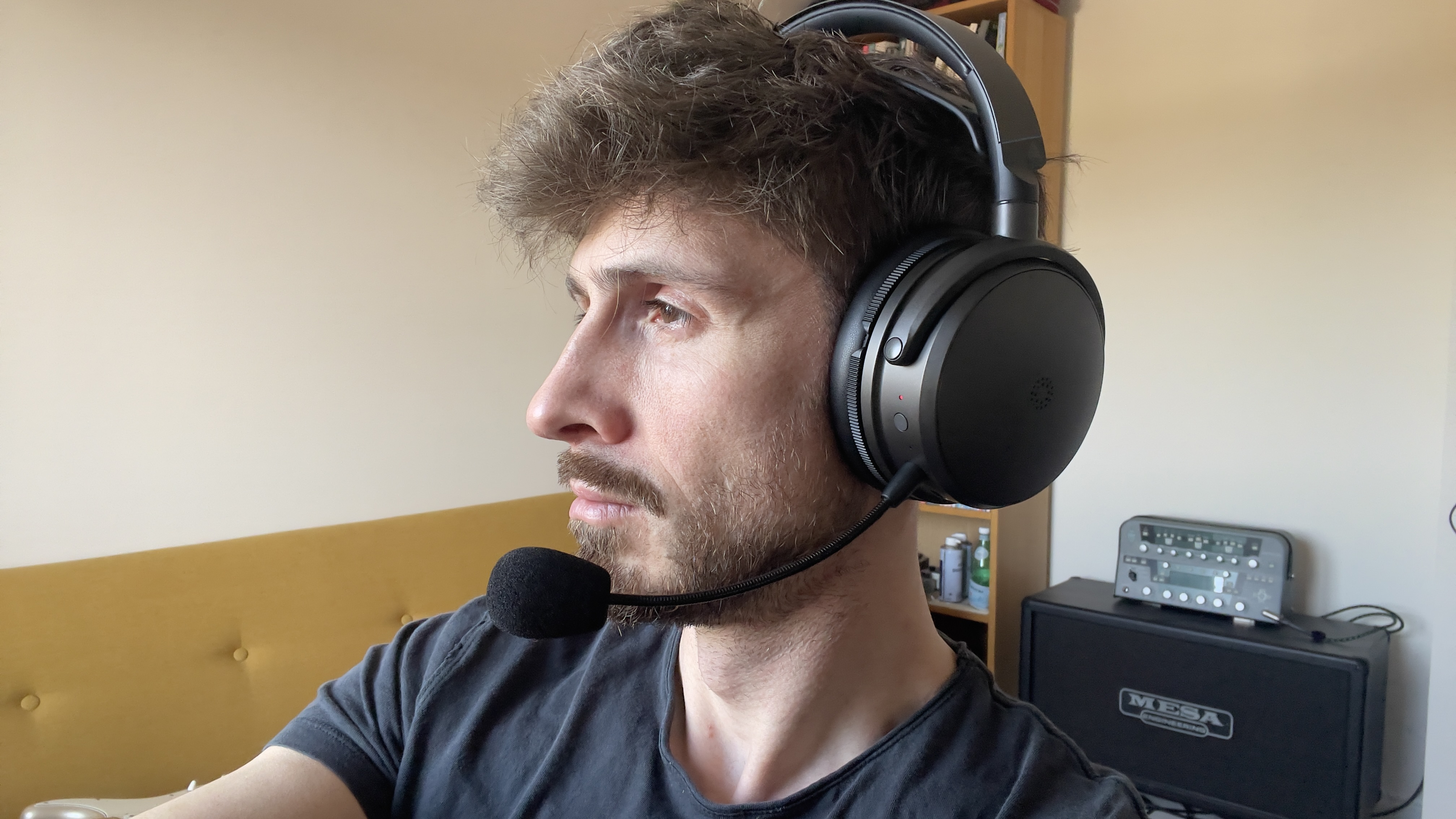 A man wearing the Audeze Maxwell 2 gaming headset showing the left side of his face and the left ear cup and microphone.