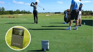 Tiger Woods strikes a golf ball on the range with the Full Swing Launch Monitor behind him