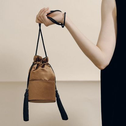 A woman carrying a tassel evening bag
