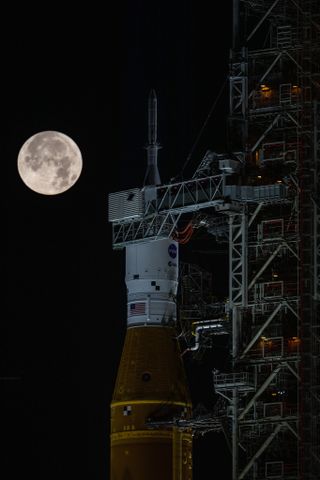 The full Strawberry Supermoon rises behind Artemis 1 at lNASA’s Kennedy Space Center in Florida on June 14, 2022.
