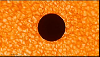 The dark disk of Mercury passes in front of the disk of the sun, as seen by the New Solar Telescope at the Big Bear Solar Observatory.