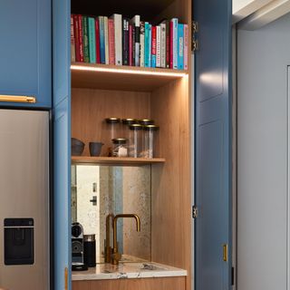 Kitchen with sink and library behind cupboard door