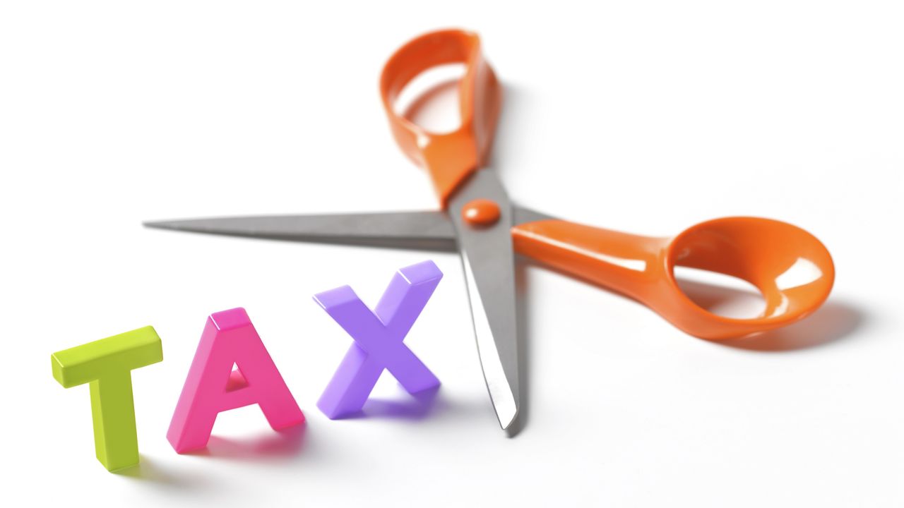 Scissors poised to cut into the word tax.