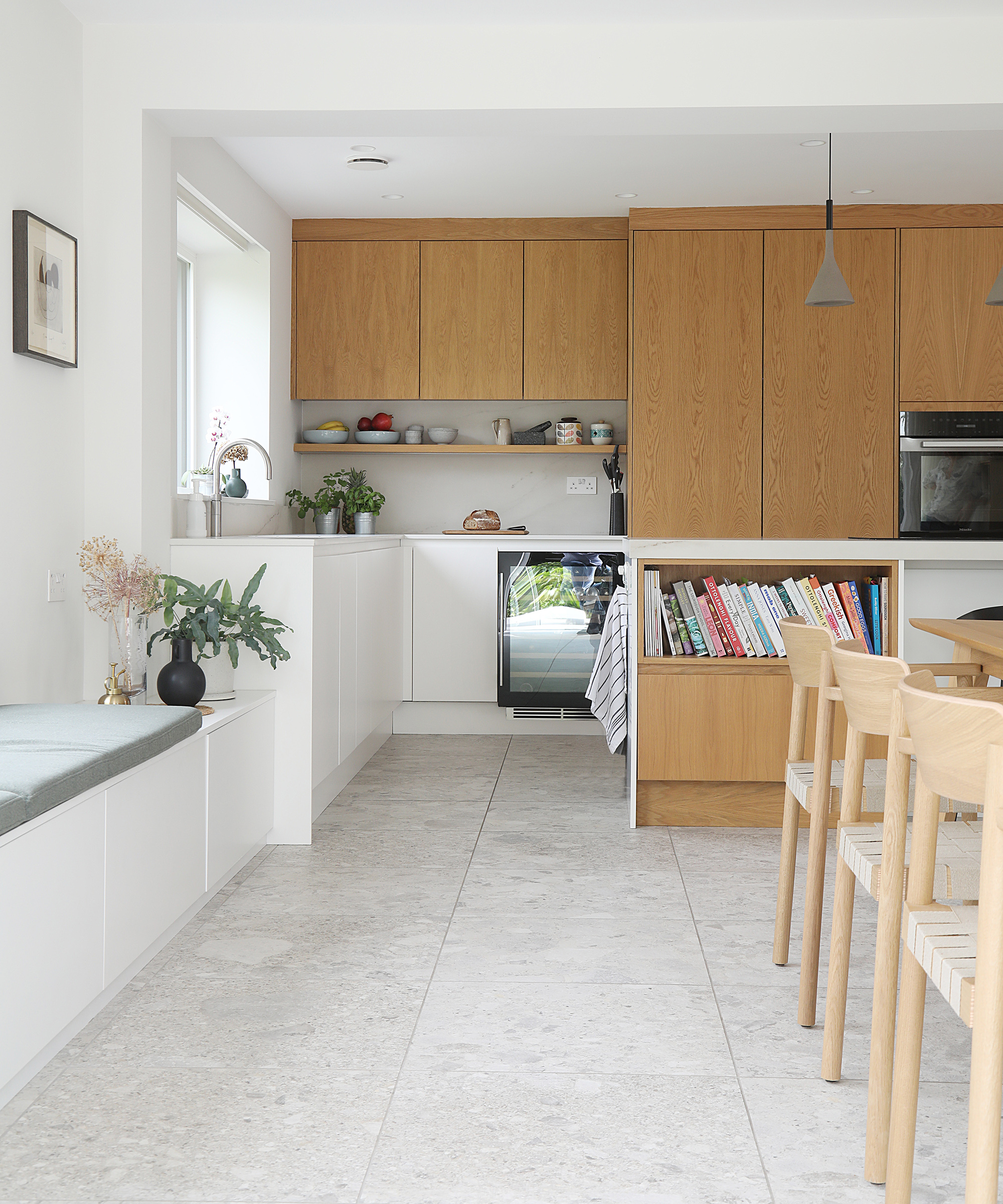 An open plan kitchen-dining room with light flooring and wooden cabinets