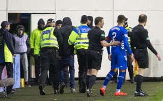 Rangers James Tavernier is pulled away from a fan that ran on to the pitch at Hibernian