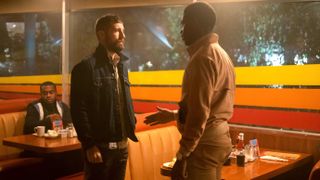 Carter Hudson as Teddy and Damson Idris Franklin staring at each other in a restaurant in Snowfall